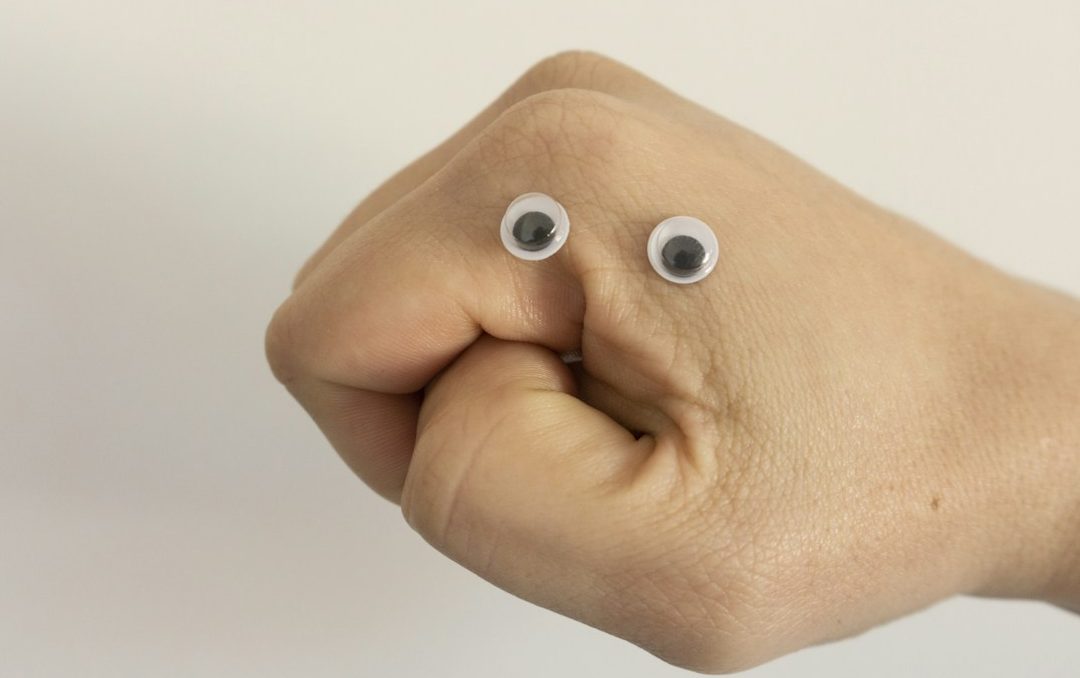 Eine geballte Faust mit wackelnden Augen auf dem Handrücken.