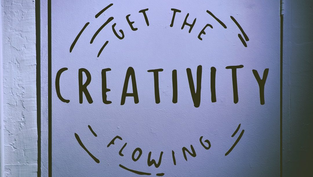 Text: "Get the creativity flowing." in kreativer Schrift auf einer Wand.