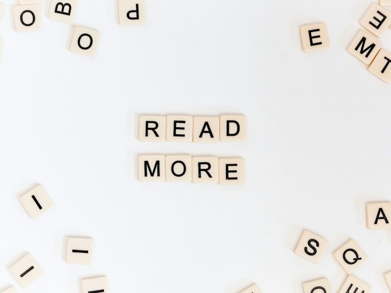 Texte erstellen mit KI? Das sollten Sie vorher gelesen haben! Holzbuchstaben bilden die Worte "READ MORE" auf einem weißen Hintergrund.