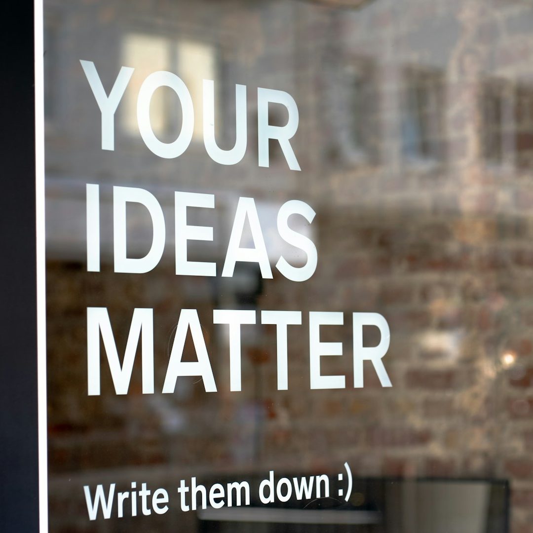 Weißer Text auf einem Fenster: "YOUR IDEAS MATTER - Write them down :)"